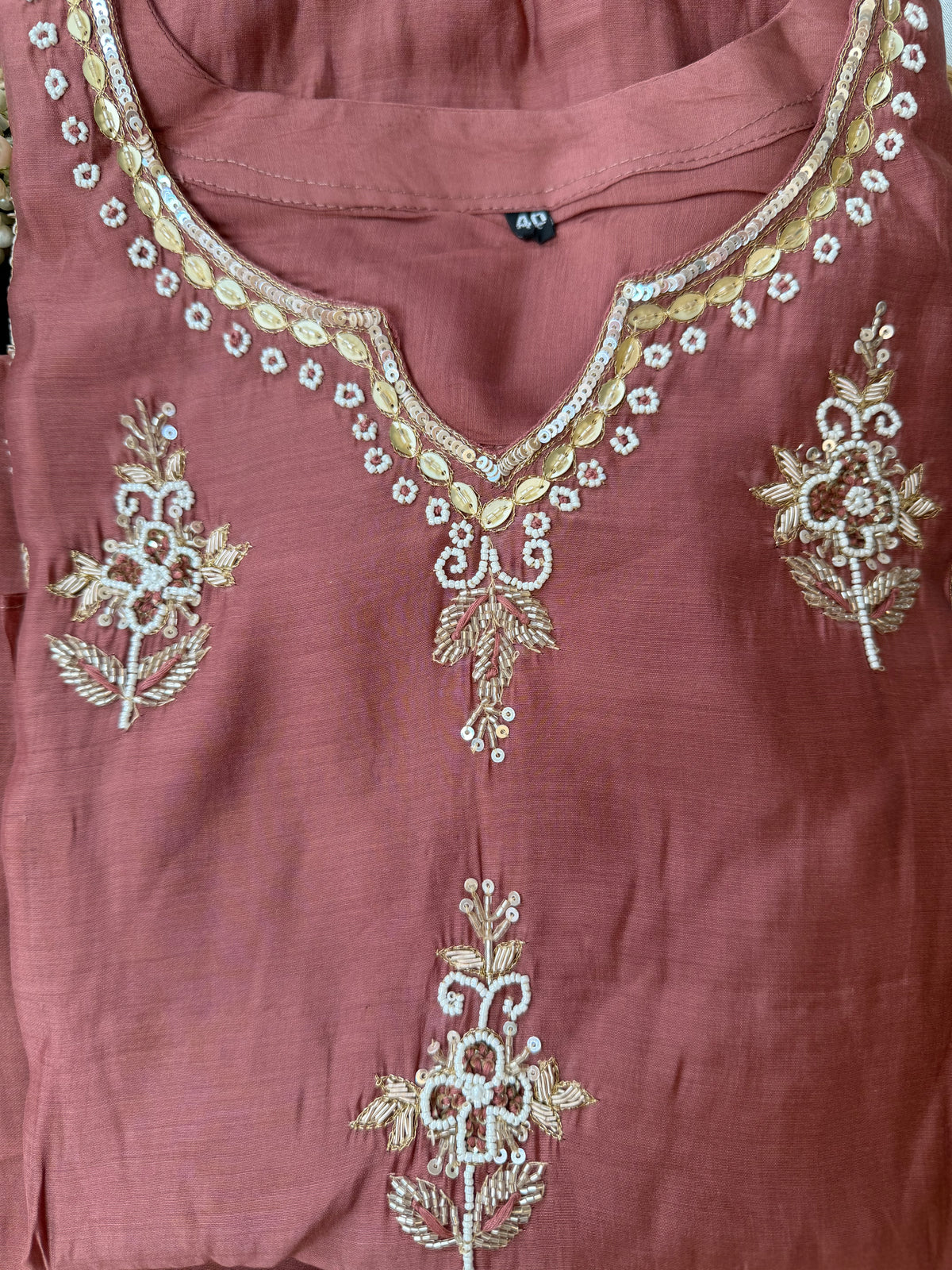 Mauve fabric with gold embroidery on a plain background