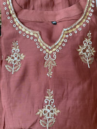Mauve fabric with gold embroidery on a plain background