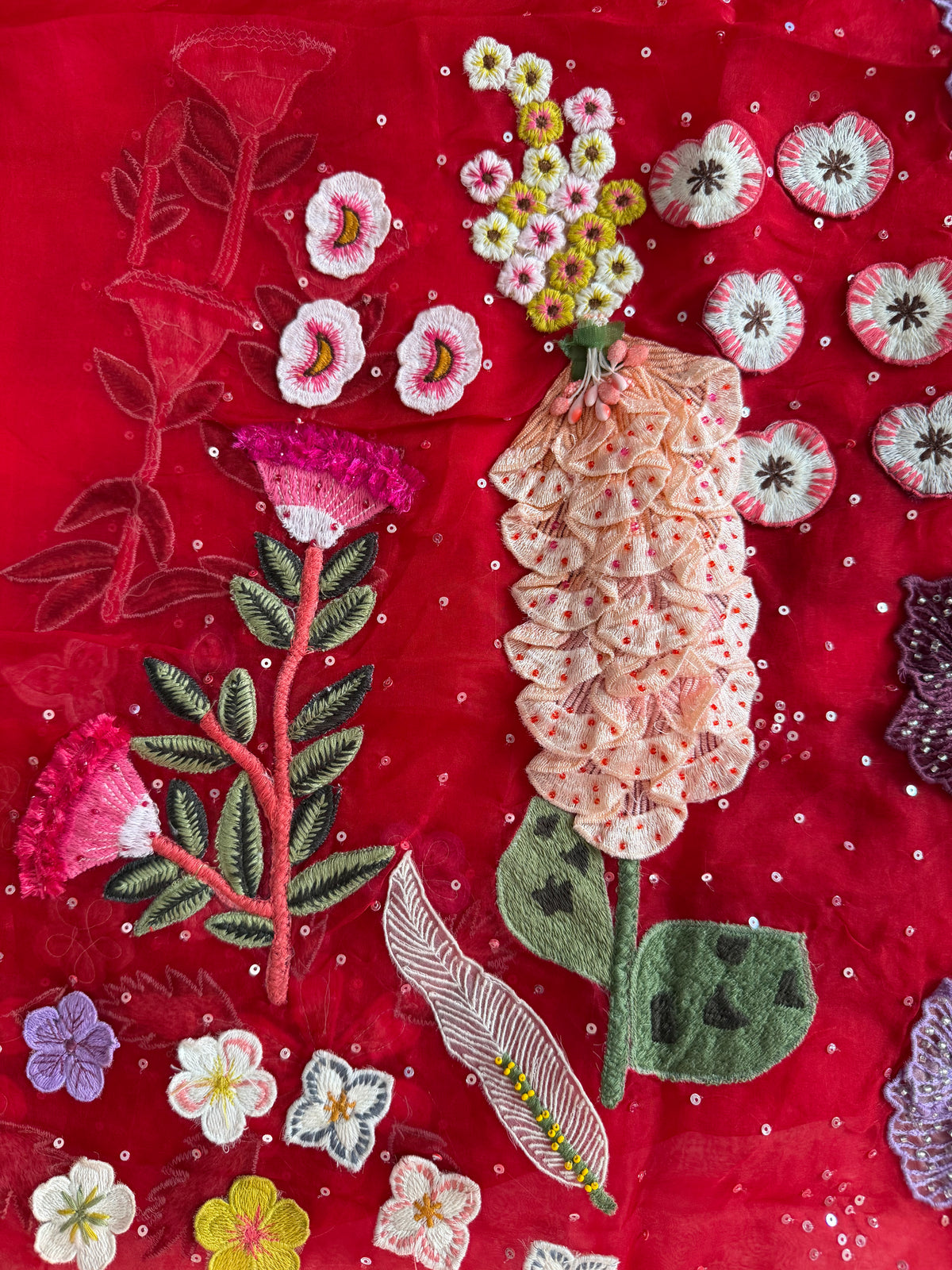 Embroidered floral design on a red fabric background